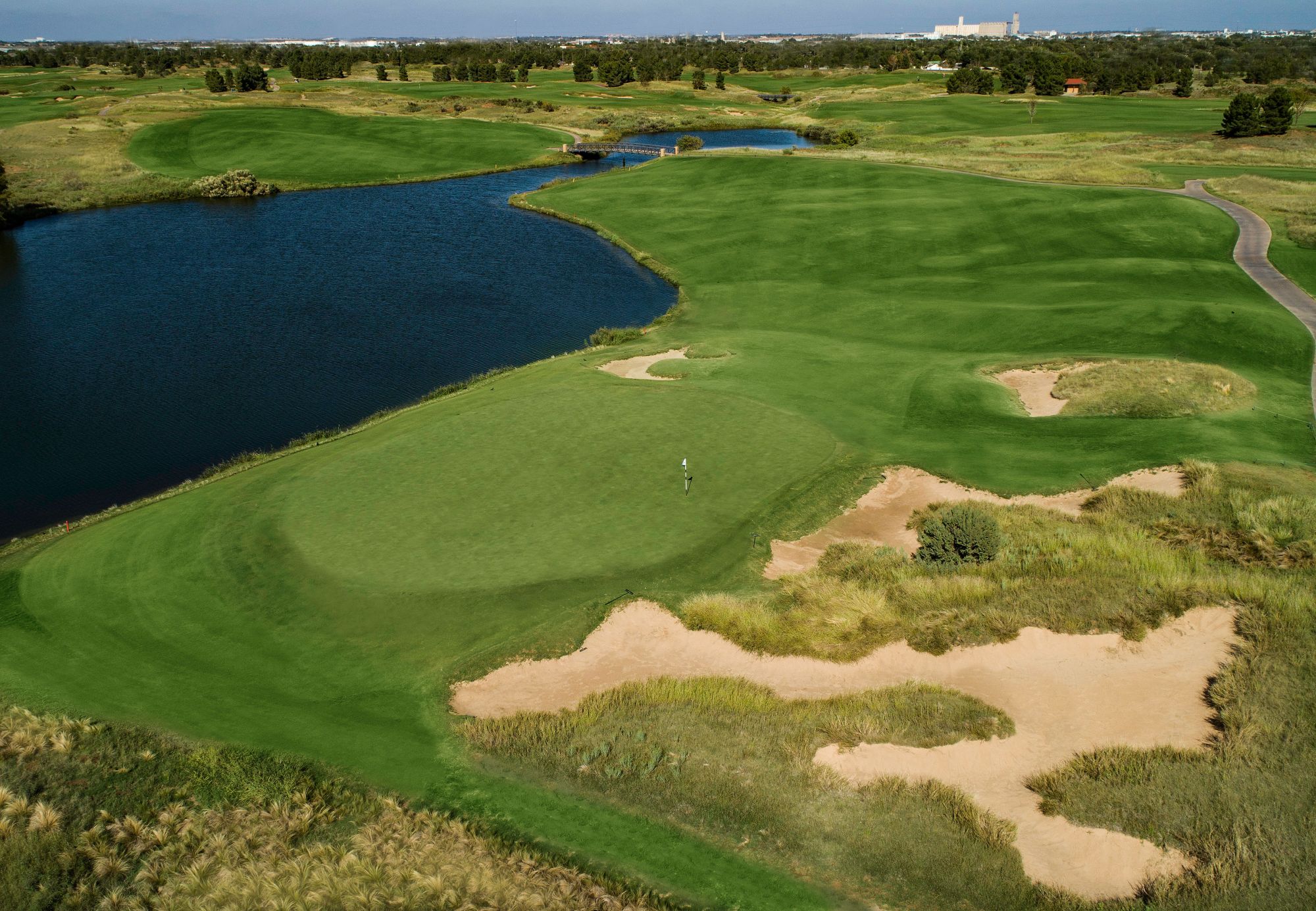 A view of a golf hole with a lake to the left.